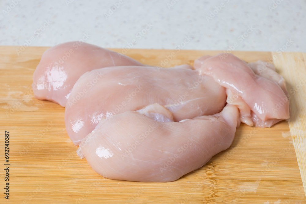 Raw meat - chicken breast on the kitchen table. Raw meat - chicken breast on the kitchen table.