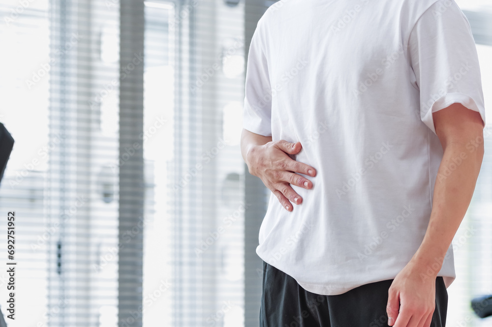 トレーニング施設で腹筋をさわっている男性 トレーニング施設で腹筋をさわっている男性