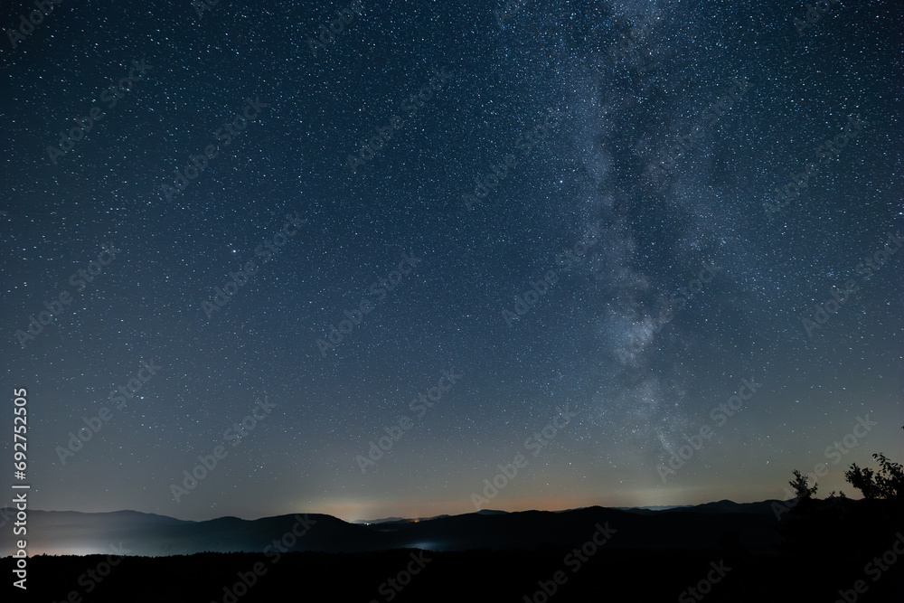 View of milky way from central europe or northern hemisphere. Sun has just set, visible silhouette of the hills.