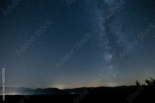 View of milky way from central europe or northern hemisphere. Sun has just set, visible silhouette of the hills.