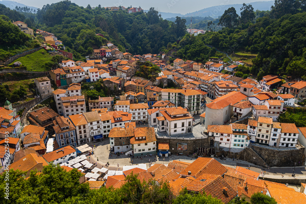 Top view of coastal village, white houses, red roofs, green hills. Cudillero, Asturias, Spain.