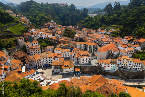 Fototapeta Naklejka Na Ścianę i Meble -  Top view of coastal village, white houses, red roofs, green hills. Cudillero, Asturias, Spain.