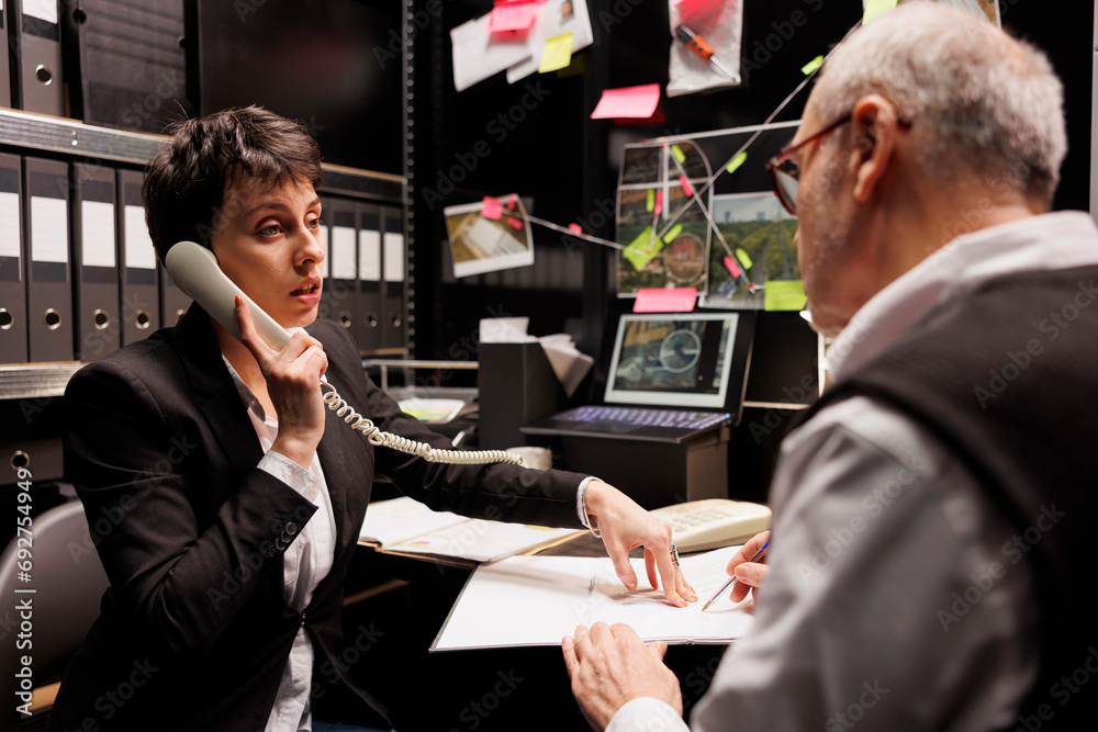 Private detective talking with remote victim at landline phone ...
