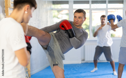 Kickboxing - an athlete kicks in sparring during training in the gym