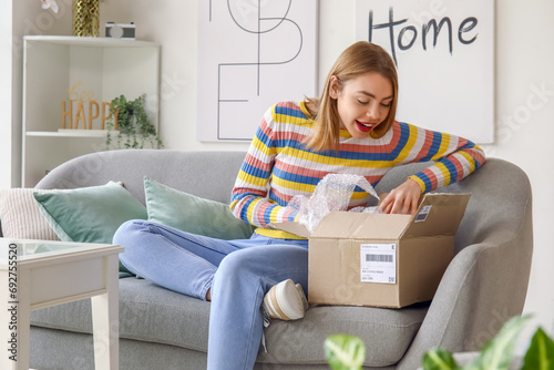 Young woman opening parcel ...