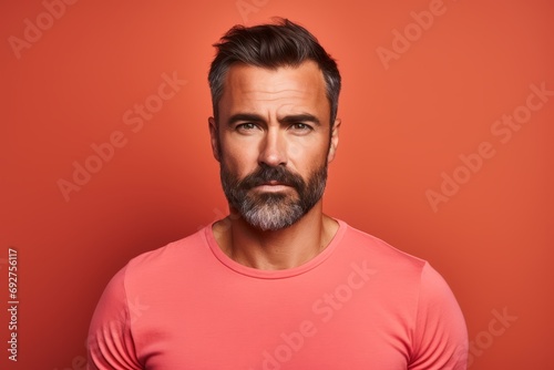 Portrait of a handsome man with beard and mustache on a red background. © Loli