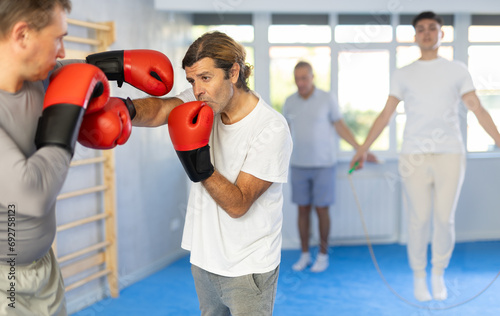 Portrait of experienced active sportsmen competing in boxing gloves