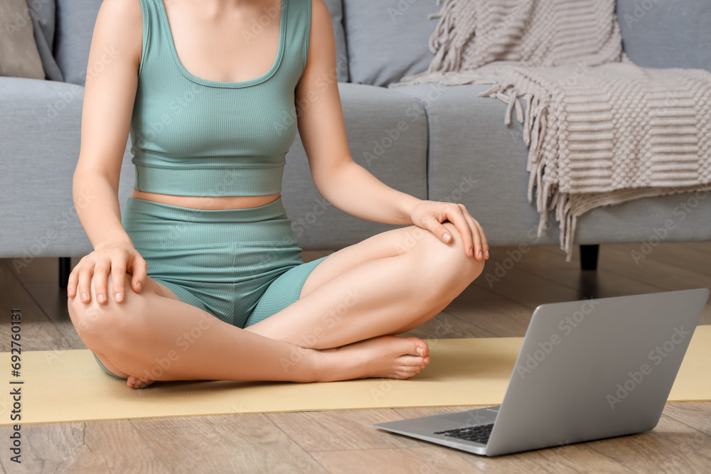 Sporty young woman with laptop relaxing at home
