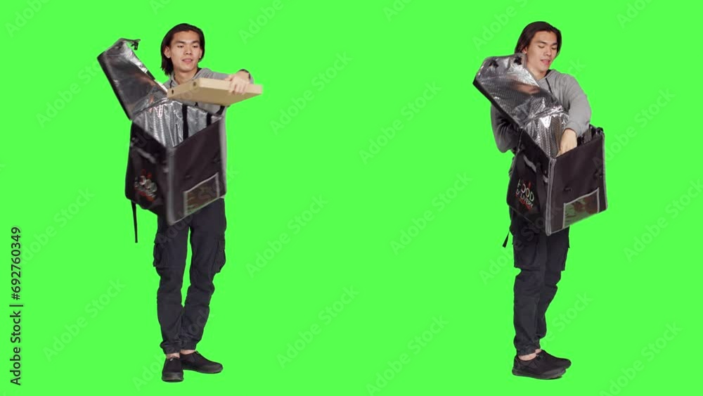 Posing over greenscreen studio backdrop, asian person working on delivering food with thermal backpack. Young adult carrying huge bag for delivery service, eager to provide good service. Posing over greenscreen studio backdrop, asian person working on delivering food with thermal backpack. Young adult carrying huge bag for delivery service, eager to provide good service.