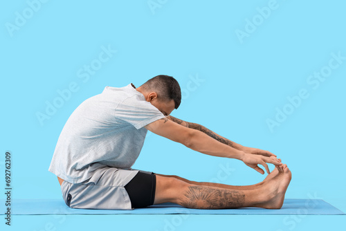 Young man doing yoga on mat...