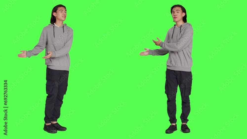 Male person creating advertisement and showing something to left or right sides on camera, pointing at thing over full body greenscreen. Young adult advertising slogan for marketing commercial. Male person creating advertisement and showing something to left or right sides on camera, pointing at thing over full body greenscreen. Young adult advertising slogan for marketing commercial.