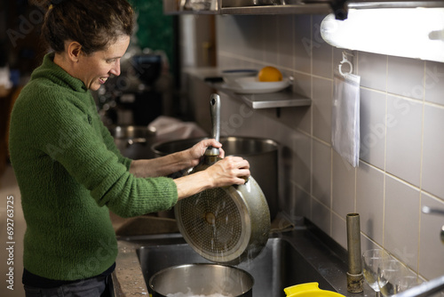 Mid Adult Woman Washing Commercialt Kitchen