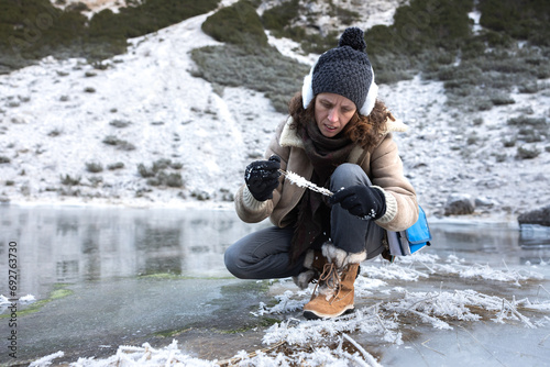 Environment Expertise Woman Collecting Samples of Frost from Frozen Lake Environment in High Mountains of European Alps photo