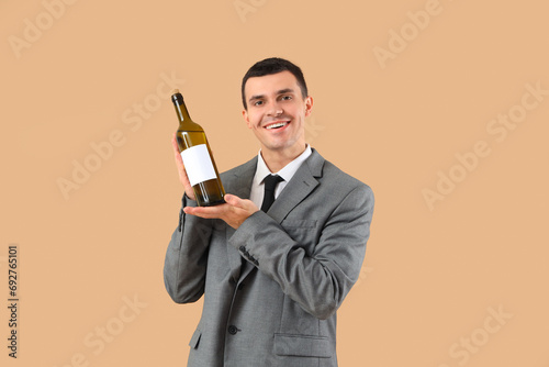 Young sommelier with bottle...