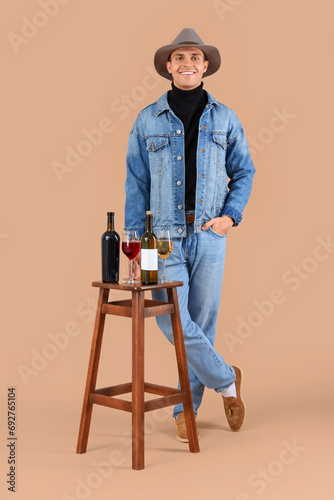Young man with wine on beig...