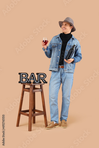 Young man with wine on beig...