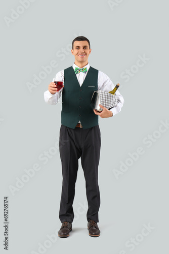 Young waiter with wine on g...