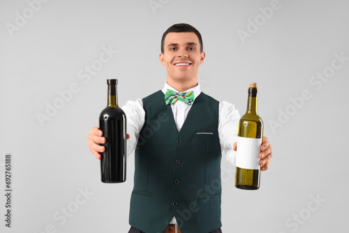 Young barman with bottles o...