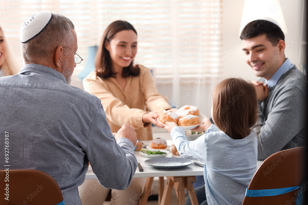 Happy family having dinner at home on Hanukkah, back view Happy family having dinner at home on Hanukkah, back view