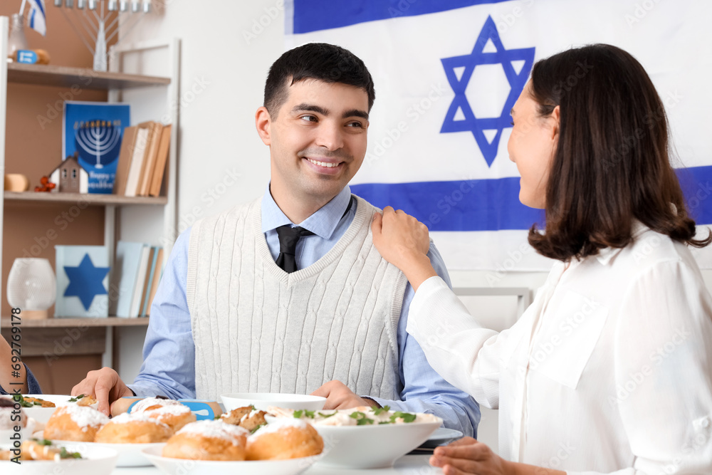 Happy Jewish couple having dinner at home on Hanukkah Happy Jewish couple having dinner at home on Hanukkah