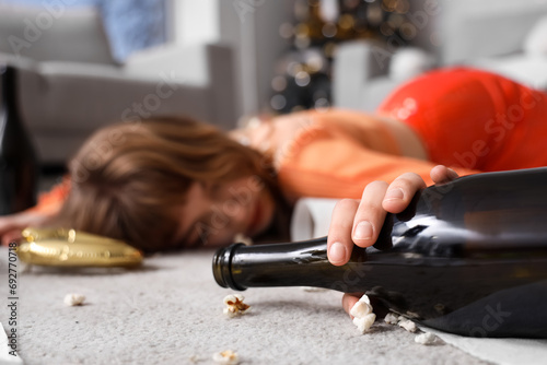 Drunk young woman sleeping on floor in messy living room after New Year party, closeup photo