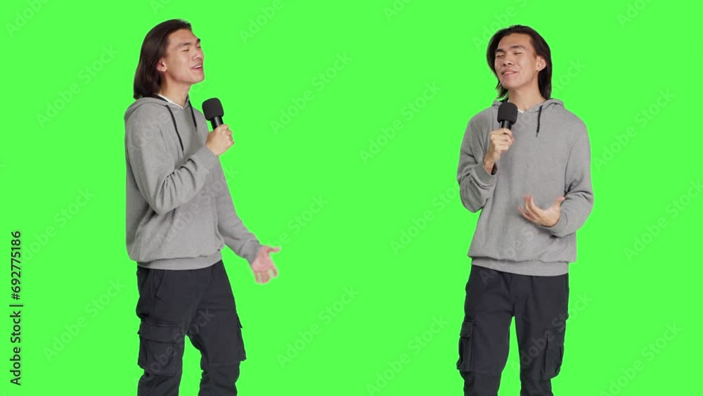 Cool person doing karaoke session on camera, using microphone to sing modern songs and lyrics. Young adult having fun over greenscreen backdrop, creating music and singing tunes. Cool person doing karaoke session on camera, using microphone to sing modern songs and lyrics. Young adult having fun over greenscreen backdrop, creating music and singing tunes.