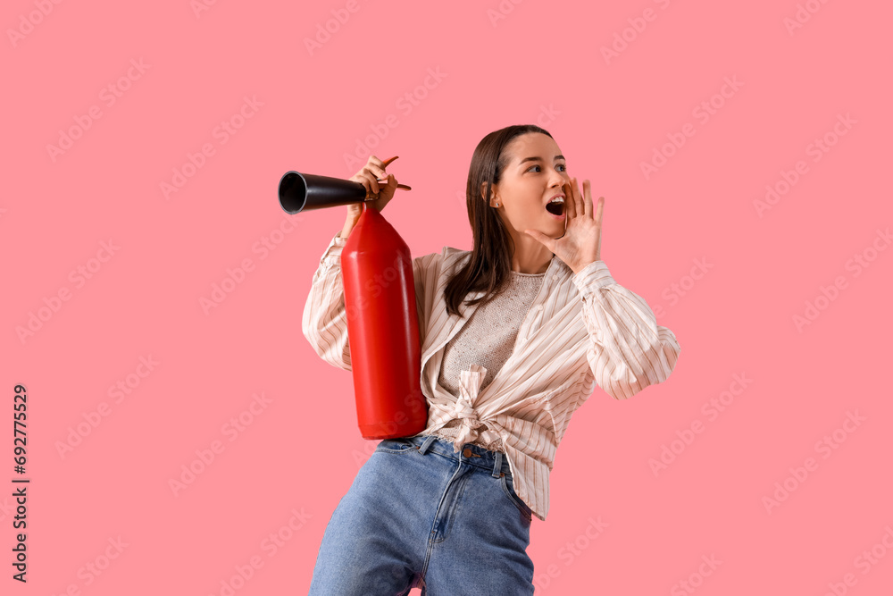 Young woman with fire extinguisher shouting on pink background Young woman with fire extinguisher shouting on pink background
