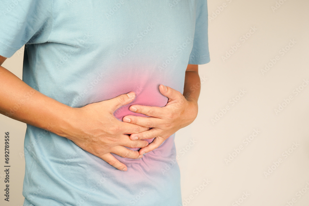 male having stomach ache, bending over and holding hands on stomach