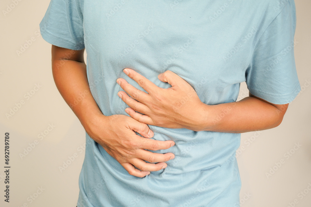 male having stomach ache, bending over and holding hands on stomach