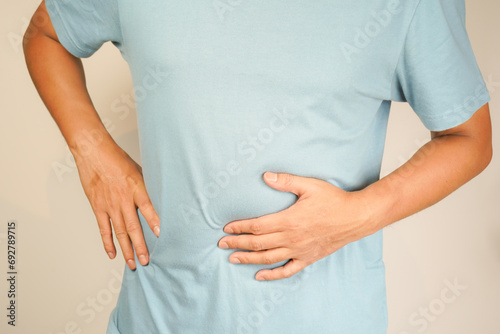 male having stomach ache, bending over and holding hands on stomach, uncomfortable due to stomach cramps, gastric pain