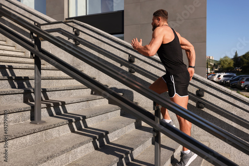 Man running up stairs outdoors on sunny day © New Africa