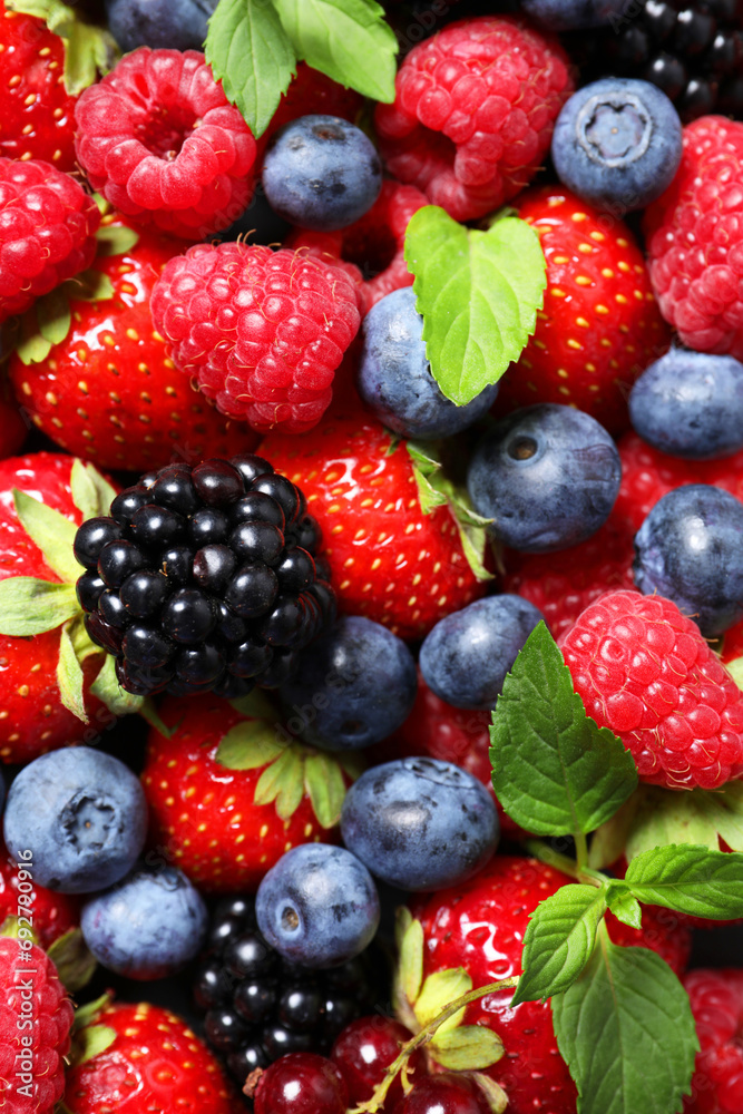Assortment of fresh ripe berries with green leaves as background, top view Assortment of fresh ripe berries with green leaves as background, top view