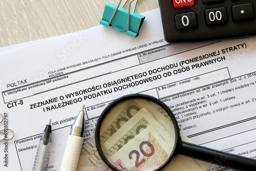 Declaration of the amount of earned income or incurred loss and corporate income tax, CIT-8 tax forms on accountant table with pen and polish zloty money bills close up photo