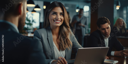 Portrait of businesswoman using laptop computer with business people working together in office