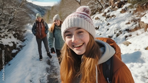 a pleasant winter hike, happy teenage girls walking along a mountain path snowy. a beautiful forest landscape. generative AI