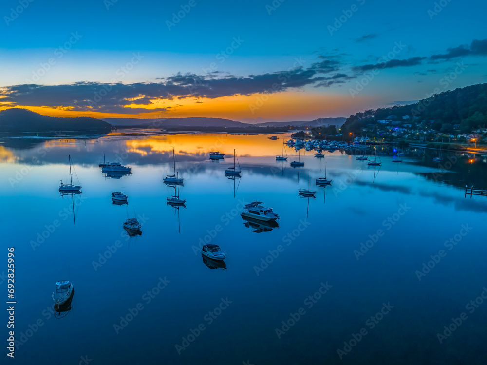Fototapeta premium Aerial sunrise waterscape with boats, reflections and low cloud