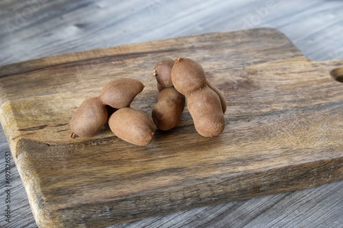 Group of tamarind fruits on wooden cutting board