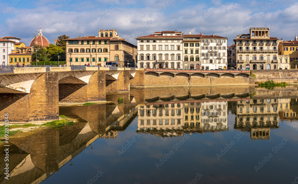 Reflections in the river of beautiful old buildings in Florence Italy