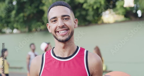 Young man, face and happy on basketball court by ball for sport, fitness and team training in outdoor. Mexican athlete, portrait and smile for strong and workout glow of cardio exercise in nature photo