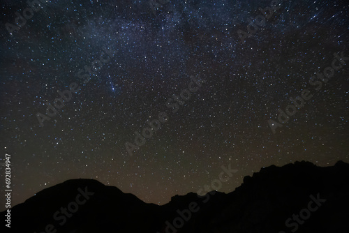 A scenic view of the Milky Way and starry night sky over the Chisos Mountains in Big Bend National Park, Texas. photo