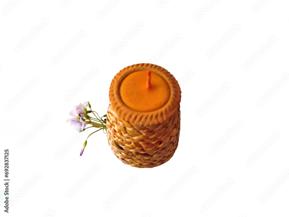 In the picture is a brown terra cotta pot woven with brown dried grass, handmade. There are candle pots nearby, and purple flowers are placed together.