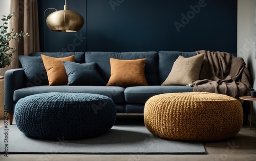 Two knitted poufs sit near a dark blue corner sofa, enhancing the space with elegant Scandinavian home interior design photo