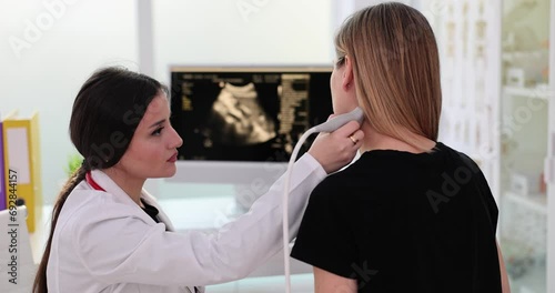 Closeup of woman having ultrasound scan of neck by doctor photo