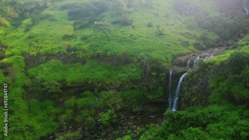 A scenic drone view of a Bahuli waterfall surrounded by lush greenery Nashik Maharashtra photo