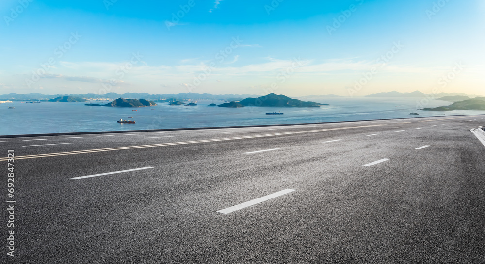 Asphalt highway road and coastline natural landscape under blue sky. High Angle view.