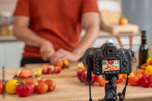 videographer record video clip back screen video recording by camera and smartphone to online social internet live. Vlogger watching recording clip streaming online a man preparation food salad. photo