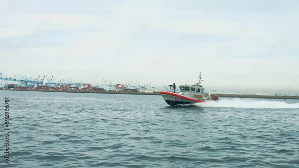 Slow motion shot of a soldier standing with a weapon on the foredeck of an American coast guard boat Slow motion shot of a soldier standing with a weapon on the foredeck of an American coast guard boat