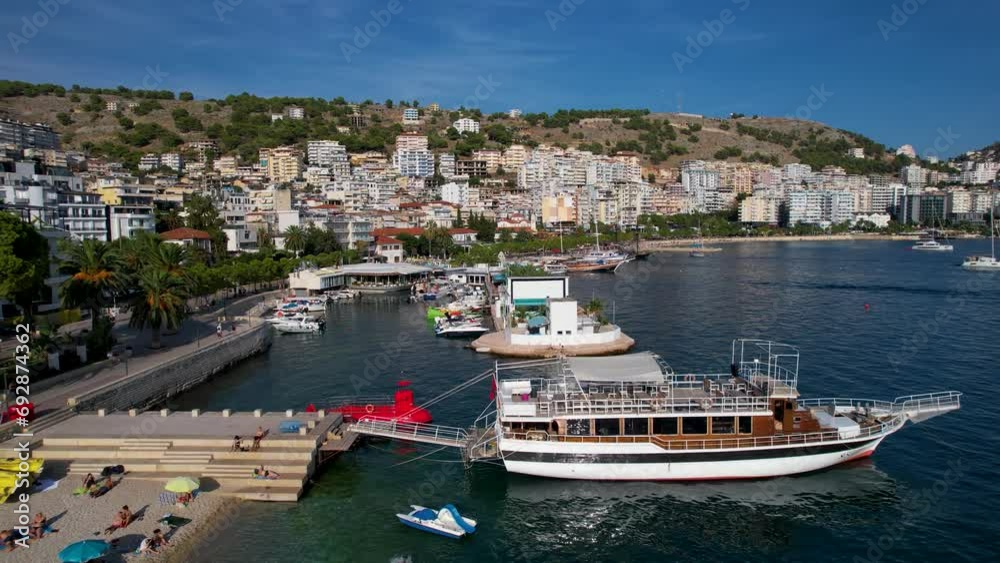 Tranquil Pier Along Saranda's Coastal City, Boats and Tour Ships Anchored in the Blue Bay for Summer Leisure Tranquil Pier Along Saranda's Coastal City, Boats and Tour Ships Anchored in the Blue Bay for Summer Leisure