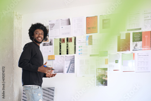 Creative Professional Presenting Design Work. Designer showcasing project layouts on wall photo