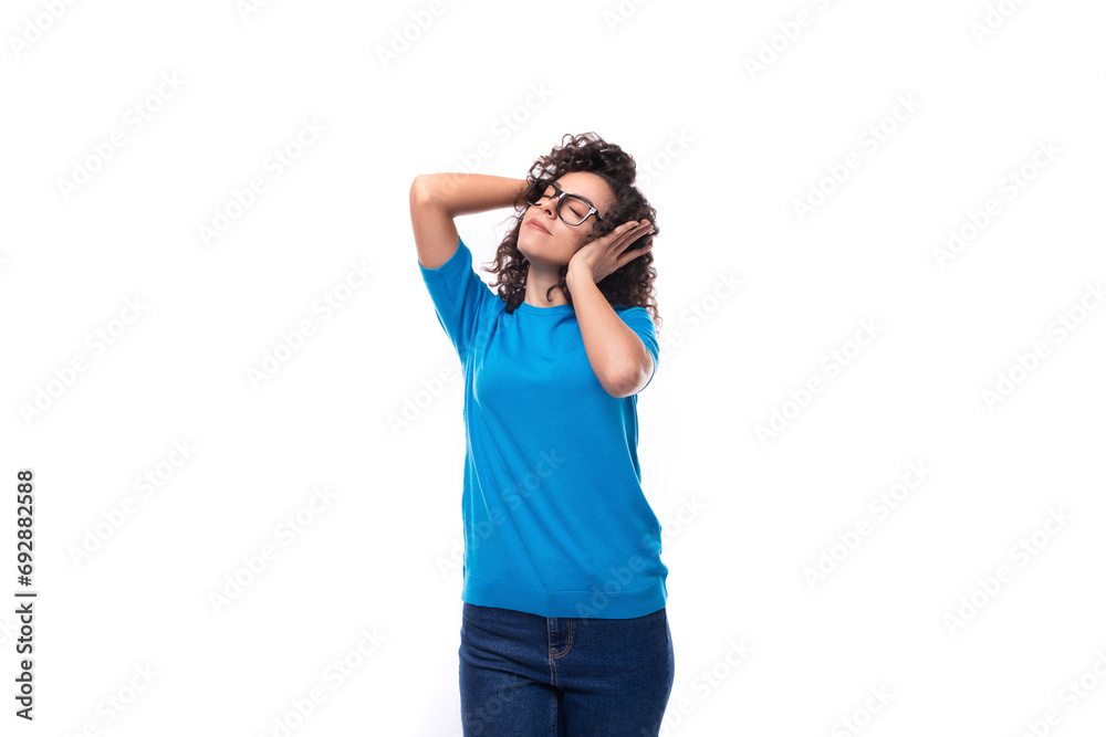 a young woman with curls wearing a blue t-shirt is trying to concentrate with her ears closed a young woman with curls wearing a blue t-shirt is trying to concentrate with her ears closed